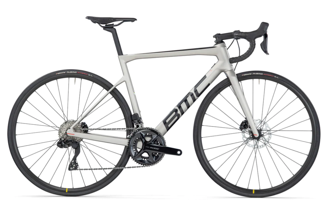 a black and white photo of a bike parked next to a clock