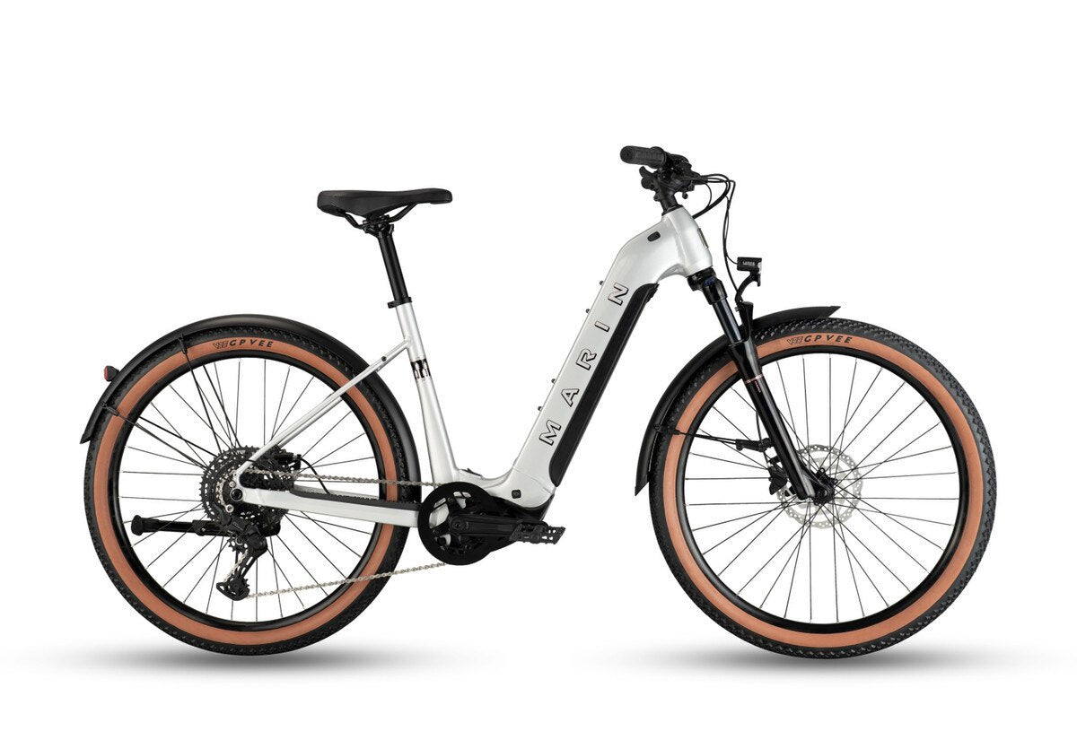 Silver electric bicycle with orange-rimmed wheels and front suspension fork