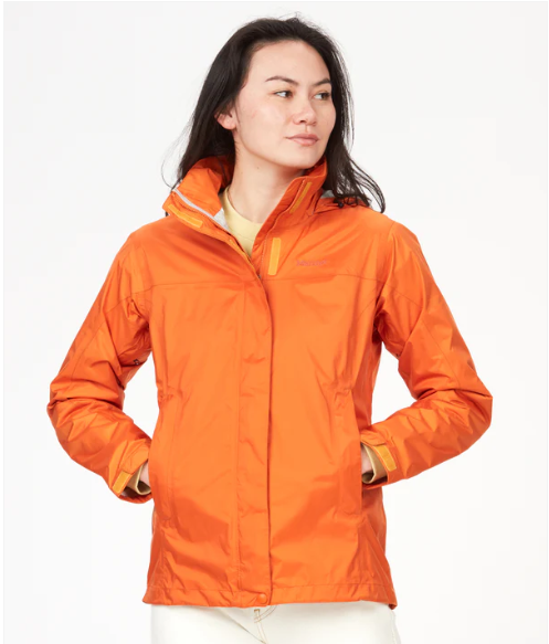 a woman in a orange outfit holding a tennis racquet 