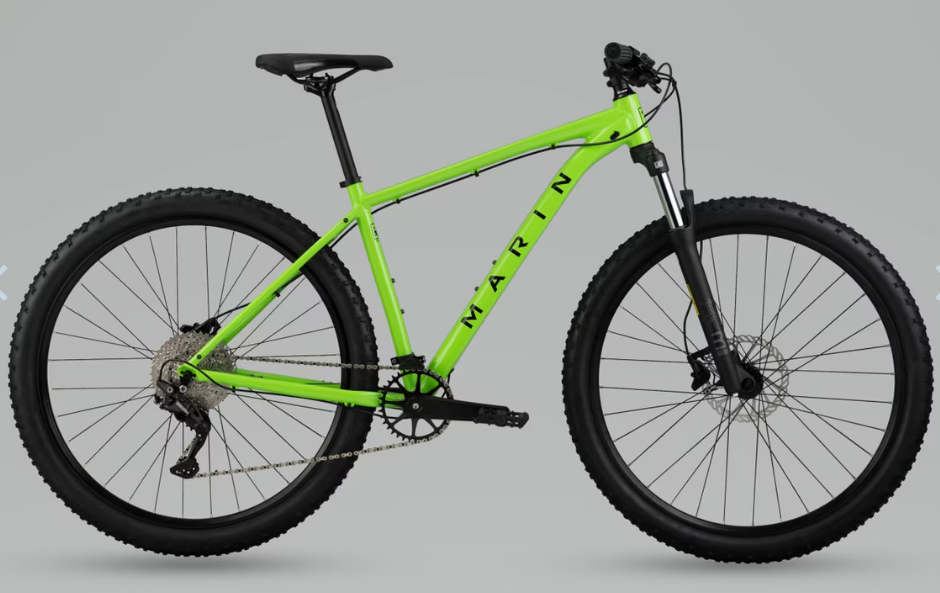 Green trail bicycle with knobby tires, disc brakes, and front suspension fork