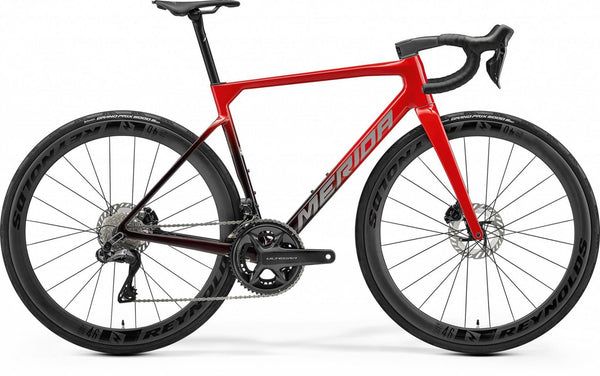 Red road bicycle with dark red frame, black wheels and drop handlebars